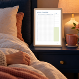 Actual January-to-December mood tracker worksheet shown on a tablet beside a warm bedside lamp.