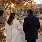 Adult partners walk and talk in a sculpture garden; illustrative open conversation